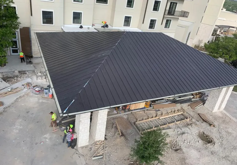 Metal roofing installation team working on a commercial building in San Bruno